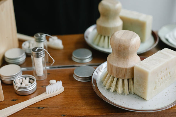 Bamboo floss, toothpaste tablets and bamboo scrub brush on a table